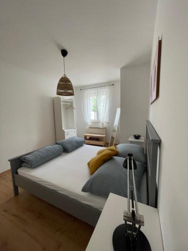 a bedroom with a bed and a desk with a lamp at Rosmarin Apartments Sea View Garden Side in Jadranovo