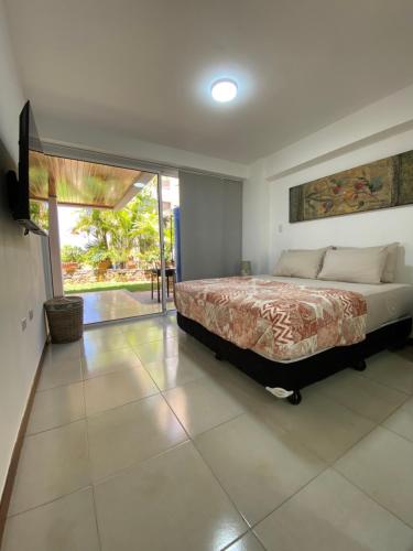 a bedroom with a bed and a sliding glass door at ¡Hermoso Apartamento en Loma Real! in Porlamar