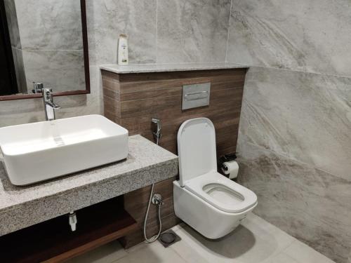 a bathroom with a white toilet and a sink at Premium&Cozy Two Beds DHA in Lahore