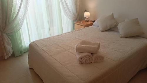 a white bed with a folded towel on it at El bon repòs del delta in El Lligallo del Gànguil