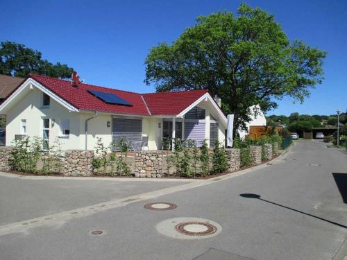 ein weißes Haus mit rotem Dach auf einer Straße in der Unterkunft Ferienwohnung Skandianvian Sol in Zinnowitz
