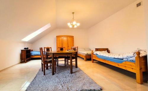 a bedroom with two beds and a table and chairs at Urszulin, centrum, tereny PPN in Urszulin