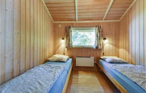 Bøtø ByにあるLovely Home In Vggerlse With Wifiのウッドウォールと窓が備わるドミトリールームのベッド2台分です。