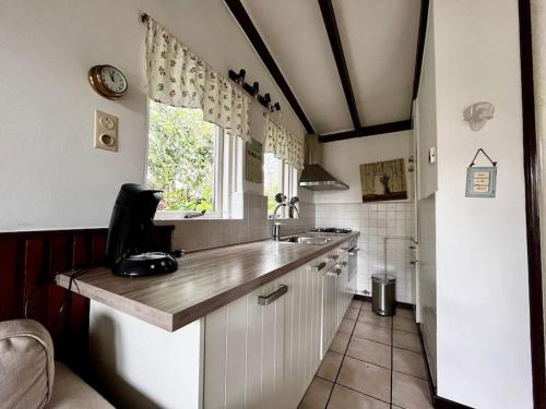 een keuken met een aanrecht en een raam bij Garnekuul 53 in Callantsoog