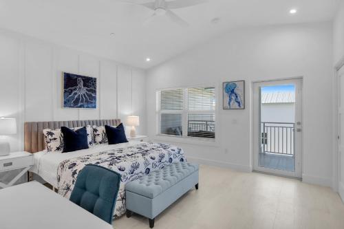 a white bedroom with a bed and a window at Peaceful Palms A2 in Islamorada