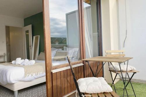 a bedroom with a bed and a table and a mirror at Le Syrme • 450m de la plage, balcon & parking in Annecy