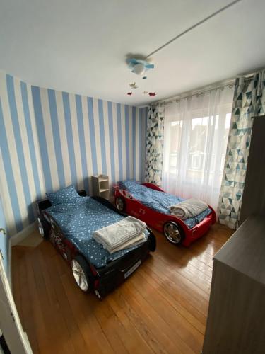 um quarto com duas camas e uma cama de carro em Maison malouine proche de plage em Dunkerque