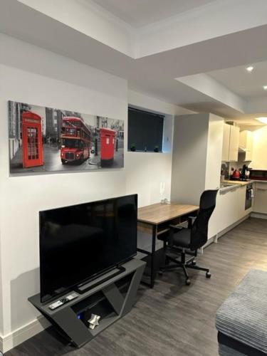 sala de estar con mesa y TV y cocina en Stunning Flat with Parking Free near Sutton Station en Cheam