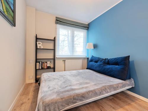 a bedroom with a large bed with a blue wall at Platinium Zaspa - Pilotów 14 in Gdańsk