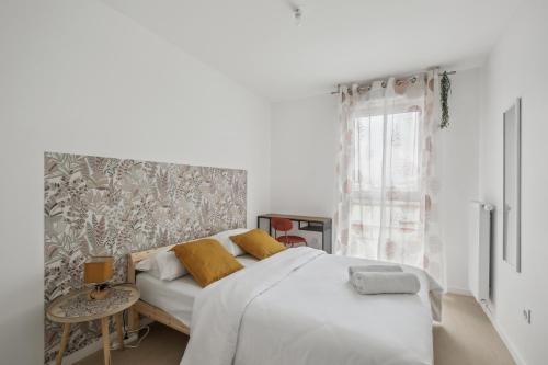 a white bedroom with a bed and a window at Chic and spacious apart with parking in Cergy
