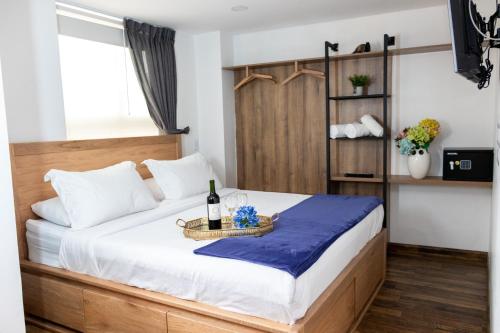 a bedroom with a bed with a tray of wine bottles at Hotel Bacata Plaza in Zipaquirá