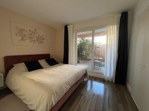 ein Schlafzimmer mit einem Bett und einem großen Fenster in der Unterkunft Hana Home T2 Guyancourt in Guyancourt