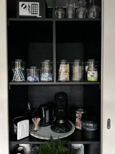 een voorraadkast gevuld met glazen potten en een koffiezetapparaat bij Bed & Breakfast in Epe