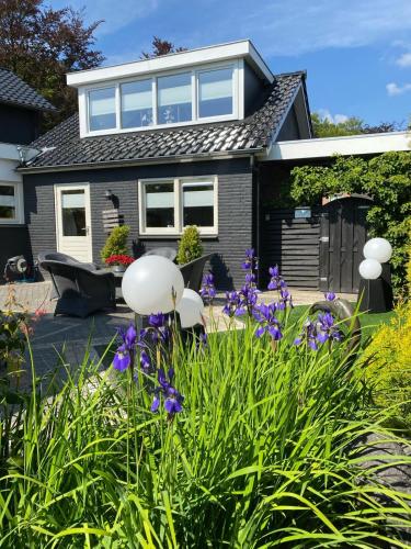 een huis met een tuin met paarse bloemen bij Bed & Breakfast in Epe