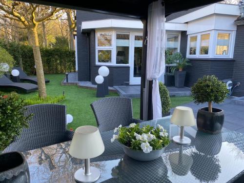 een patio tafel met twee lampen en bloemen erop bij Bed & Breakfast in Epe