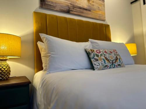 um quarto com uma cama com almofadas brancas e um candeeiro em Kings Head Coltishall em Norwich