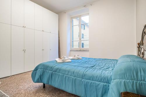 Un dormitorio con una cama azul y una ventana en Casa Shakespeare, en La Spezia
