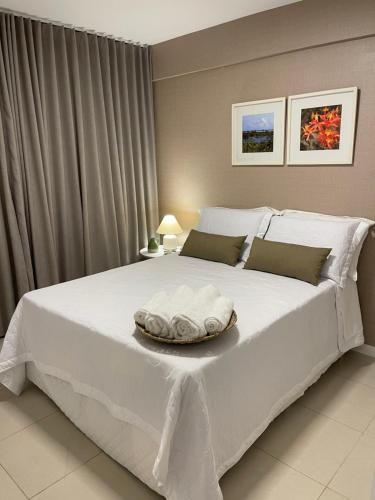 Un dormitorio con una gran cama blanca y una bandeja. en Novo quarto e sala - J. Armação - Vista Mar!, en Salvador