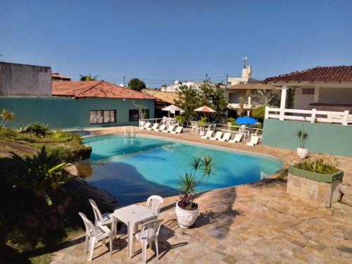 瓜拉帕里的住宿－格拉帕薩達酒店，一个带白色椅子和桌椅的游泳池