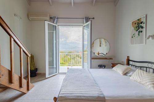 1 dormitorio con cama y ventana grande en Aria, en Lakíthra