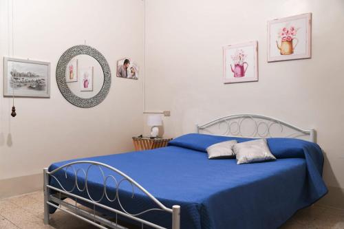a bedroom with a blue bed and a mirror at Casa Santacroce in Scilla