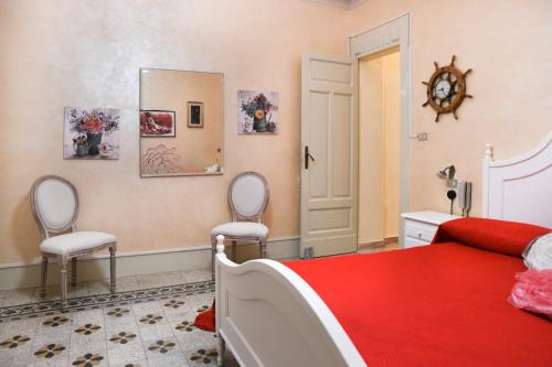 a bedroom with a bed and two chairs and a mirror at Casa Santacroce in Scilla