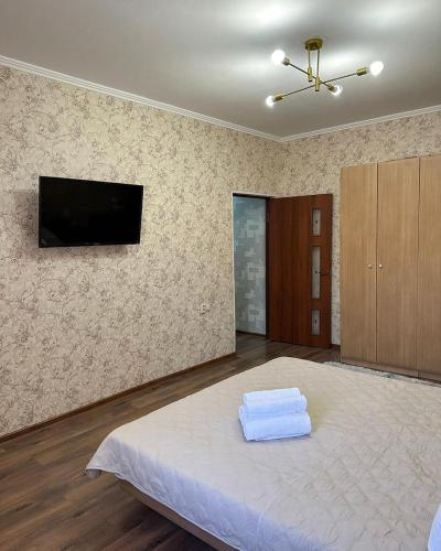 um quarto com uma cama com duas toalhas em EASY RenT Taraz em Taraz