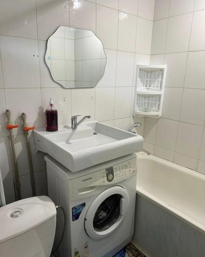 uma casa de banho com uma máquina de lavar roupa e um lavatório em EASY RenT Taraz em Taraz