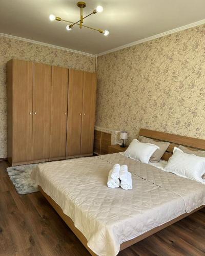 um quarto com uma cama grande com duas toalhas em EASY RenT Taraz em Taraz