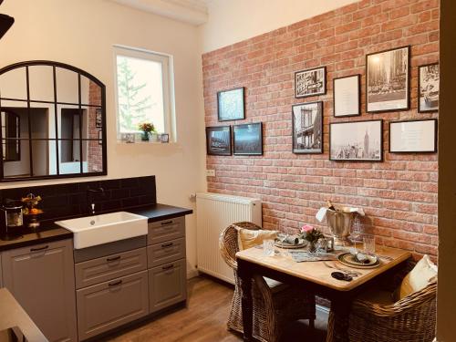 een badkamer met een wastafel en een bakstenen muur bij The Hampton Hock's - Wellness & Wine in Freinsheim