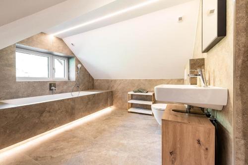 a bathroom with a sink and a bath tub at Apartment Tschirgant Deluxe in Imst