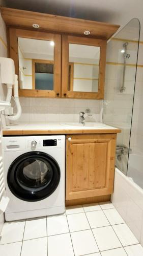 une cuisine avec une machine à laver et un évier dans l'établissement La rivière d'argent T3 Serre Chevalier Pied des pistes, à Saint-Chaffrey