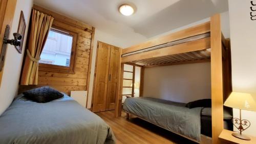 a bedroom with two bunk beds and a window at La rivière d'argent T3 Serre Chevalier Pied des pistes in Saint-Chaffrey