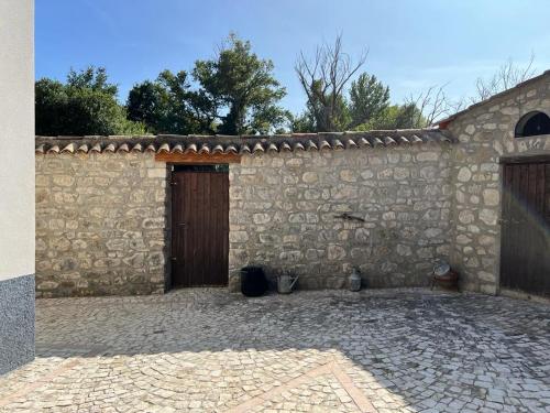 a stone building with a door and a brick courtyard at Fattoria F.lli Marsolo in Chiusa Sclafani