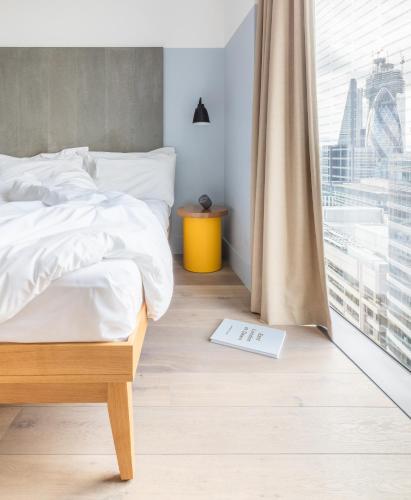 a bedroom with a bed with a book on the floor at Leman Locke in London