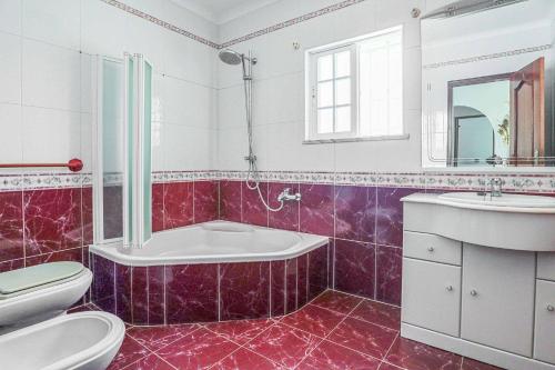 a bathroom with a tub and a toilet and a sink at Villa Vivienda Rosa in Albufeira