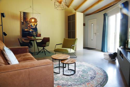 a living room with a couch and chairs and a table at Silo 161 in Ruinerwold