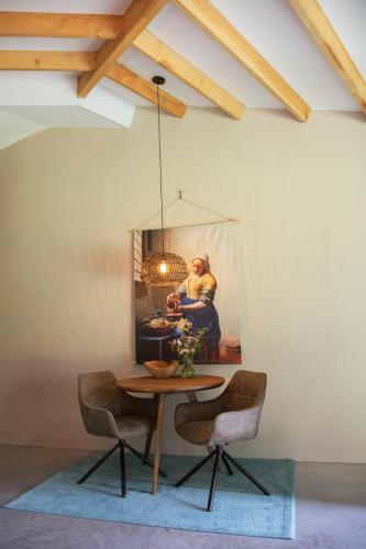 a dining room table with chairs and a painting on the wall at Silo 161 in Ruinerwold