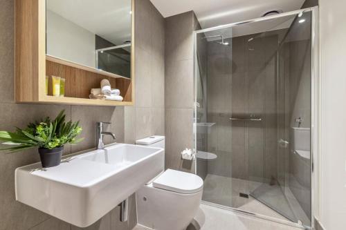 uma casa de banho com um WC, um lavatório e um chuveiro em Modern Urban Oasis 2 bed Apartment em Melbourne