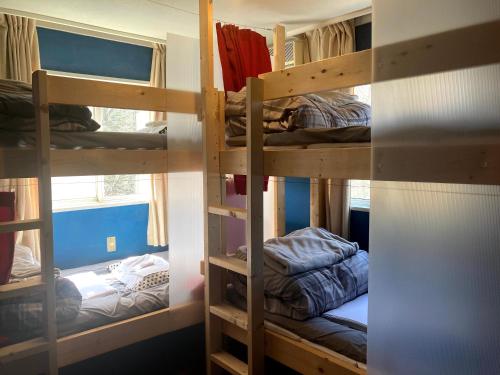 a room with three bunk beds in a room at Bellscabin Guesthouse in Karuizawa