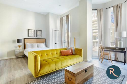 a hotel room with a yellow couch and a bed at Roami at Canal Quarters in New Orleans