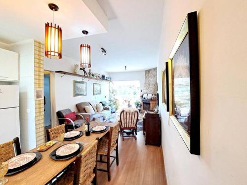 een keuken en een woonkamer met een tafel en stoelen bij Apto Varanda Verde com Lareira in Campos do Jordão