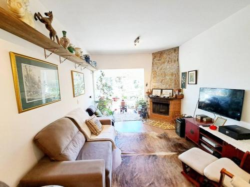 a living room with a couch and a fireplace at Apto Varanda Verde com Lareira in Campos do Jordão