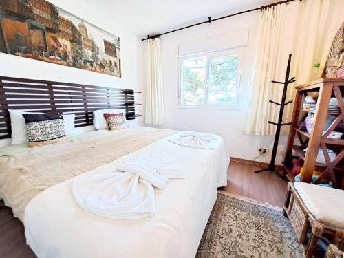 een slaapkamer met 2 bedden en een raam bij Apto Varanda Verde com Lareira in Campos do Jordão
