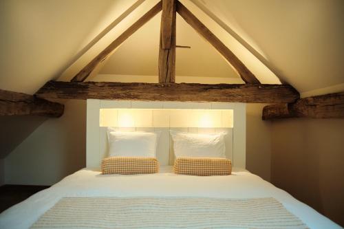a bed with two pillows on top of it at Penthouse : immersion dans la nature in Durbuy
