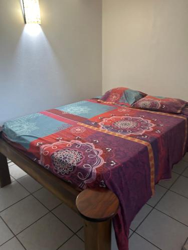 Rivière-Pilote的住宿－Domaine de kanelle，床上有红蓝色的毯子