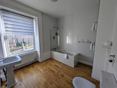 a bathroom with a tub and a sink and a window at The Havelock in Nairn