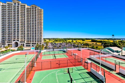 a tennis court with two tennis courts in front of a building at Surfside Resort in Destin