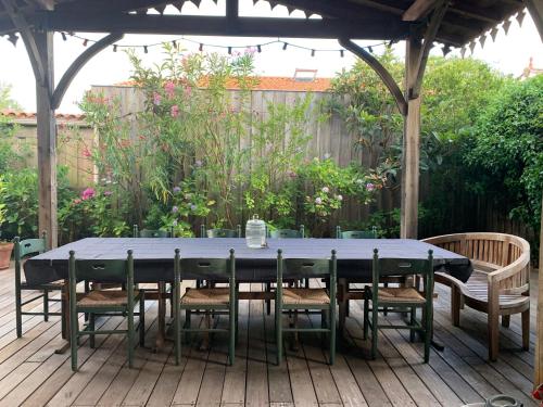 une table bleue et des chaises sur une terrasse en bois dans l'établissement Magnifique villa à 3 mn de l'ocean, à Carcans