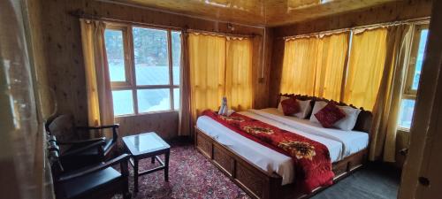 a bedroom with a bed in a room with windows at New Snow View Resort pahalgam in Pahalgām